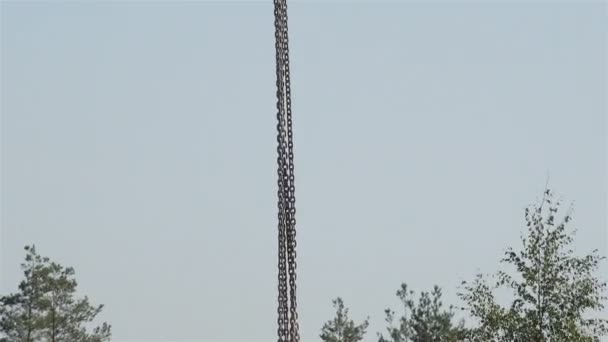 Certains cercles suspendus sur les chaînes de la grue à la haute altitude contre un ciel bleu — Video