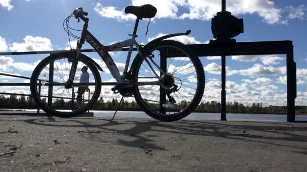 Russia, St. Petersburg, Peterhof, October 3, 2015 people on the background of bicycles stood on the dock and breathe fresh air while enjoying the environment, and white floating clouds — Stock Video