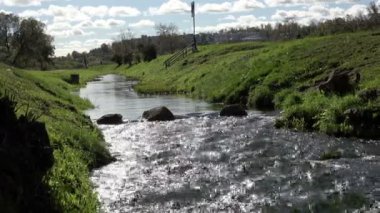 Yeşil ot ve dik bankalar taş kayalar yıkayarak temiz su bir kentsel ortamda bozulmamış Nehri akar