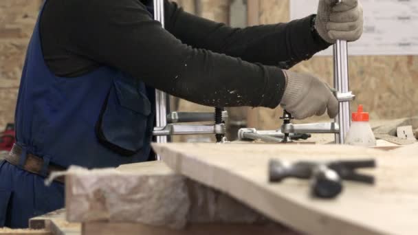 Miembro del personal especialmente capacitado instala una base de madera vise apretones y atornillar uniformemente relé de desplazamiento — Vídeo de stock