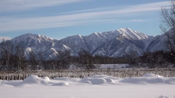 Osamělý kopce a vrcholky hor pod sníh a ledově studená modrá obloha — Stock video