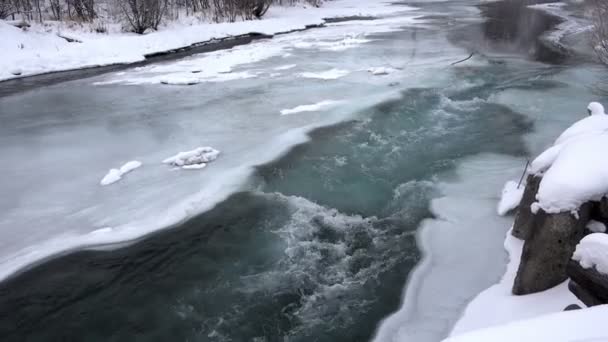 Schnelles Fließen des Wassers flussabwärts durch das eisige Tauwetter dunkelblau — Stockvideo