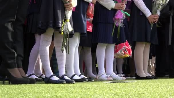Alunos do ensino fundamental estão segurando flores em uniforme escolar no festival em 01 de setembro — Vídeo de Stock