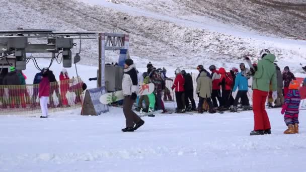 RUSIA, REGIÓN DE LENINGRAD PARQUE TUUTARI, 2 DE ENERO DE 2016: niños y adultos que practican deportes de invierno en el pabellón de esquí Montar en pistas de montaña sobre tablas de snowboard y esquís — Vídeos de Stock