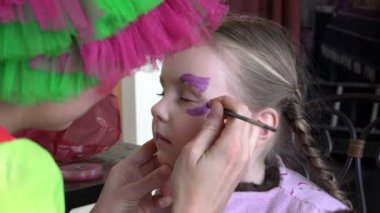 profesyonel makyaj ve manikür sebze boyaları uzmanı Childs'ın yüz kelebek şeklinde desen gerçekleştirir