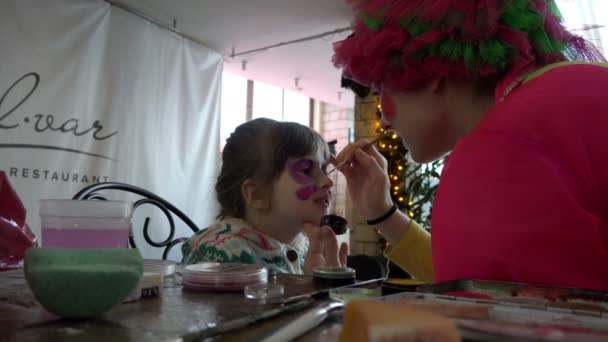 Ryssland, St Petersburg, januari 10, 2016: noggranna arbete med akvagrimom vid utskrift på ett barns ansikte med en borste — Stockvideo