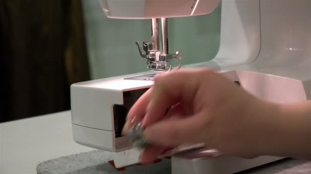 Female hand inserts the bobbin case with the pin in the needle plate — Stock Video