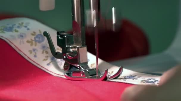 Sewing machine needle pierces the elastic tape to the fabric making joint red thread — Stock Video