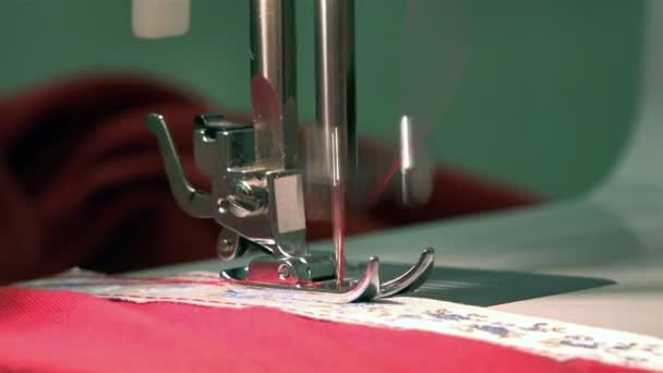 Needle plate sewing machine slides along the webbing tissue penetrating needle with red thread — Stock Video