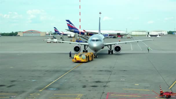 모스크바 셰레메티예보 공항, 러시아 - 2016년 6월 25일: 활주로에서 견고한 커플링 택시 여객기에 견인 트럭 — 비디오
