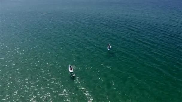 Surfeurs rame lentement sur la mer d'émeraude — Video