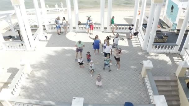 Happy tourists stand on the beach and wave at the camera — Stock video