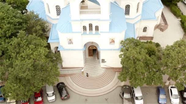 Дівчинка в чорному платті виходить з православної церкви. — стокове відео