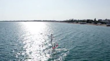 Bir adam su yüzeyinde yelken altındaki bir ışık panosunu kontrol eder.