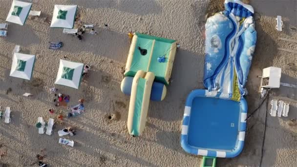 Um trampolim inflável é transportado para a costa — Vídeo de Stock