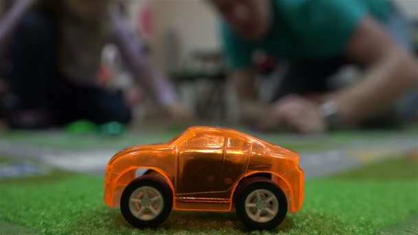 Игрушечный автомобиль на оранжевом фоне — стоковое видео