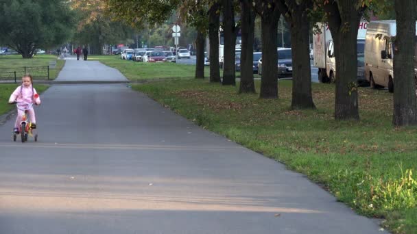 Sint-Petersburg, Rusland-September 28, 2014, kind een fiets rijdt op de stoep van de stad langs de snelweg — Stockvideo