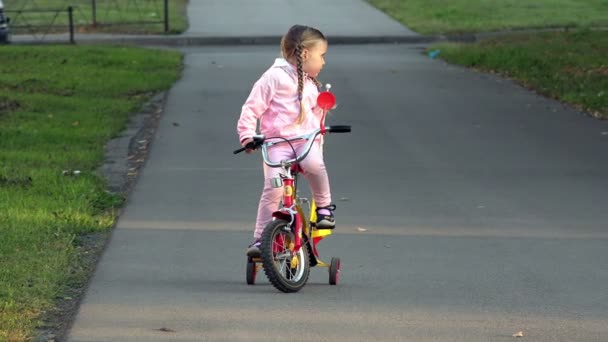 Barn cyklar på en liten ljus 4k — Stockvideo