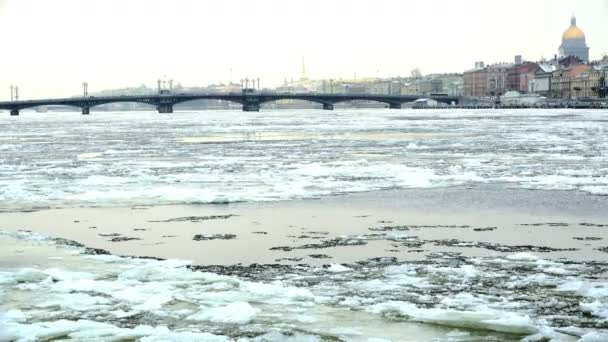 Morceaux de glace se déplaçant le long de la rivière Neva avec vue sur le pont d'Annonciation — Video