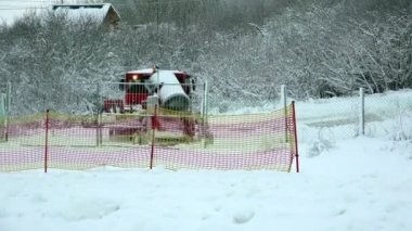 Kışın traktör karda çekili dağlarındaki doldurmak için bir silah taşıyor ve yapay kar kayak ve snowboard Kayak insanlar için hills