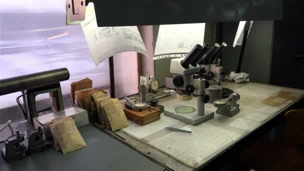 SAINT-PETERSBURG, RÚSSIA-29 de dezembro de 2014, a antiga fábrica para a produção de relógios "O Foguete", capataz de turno de mesa na fábrica com um microscópio e outros instrumentos . — Vídeo de Stock
