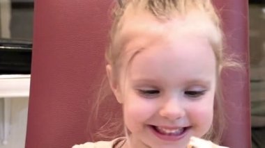 küçük bir kızın bir sandalyede oturan Frank kahkaha