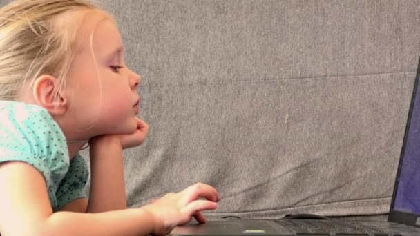 Lány feküdt a kanapén, hogy a készülék megérti notebook — Stock videók