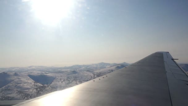 Pilotando un avión en el cielo sobre las montañas bajo el sol invernal — Vídeos de Stock