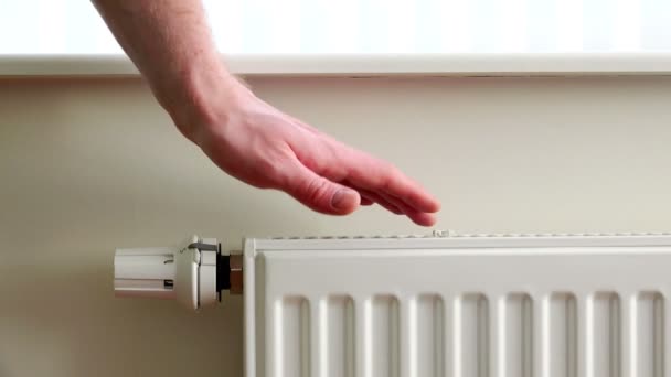 Homem ajusta a temperatura ambiente pelo radiador — Vídeo de Stock