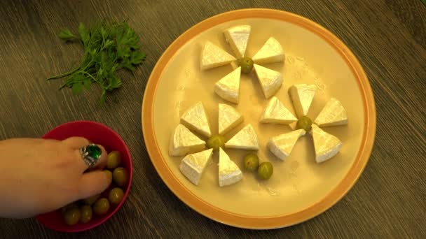 Hand serve snack on a plate you spread cheese olives and herbs — Stock Video