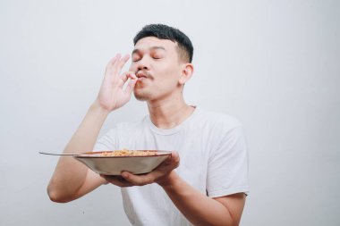 Bir adam yemeğinden zevk alır, basit bir ortamda her lokmanın tadını çıkarır..