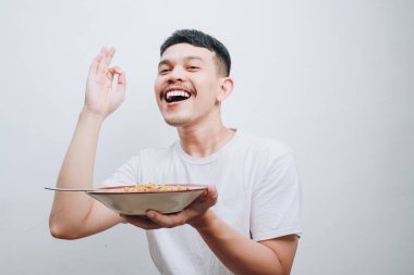 Neşeli bir adam yemeğinin tadını çıkarır, zevk ve memnuniyetini ifade eder..