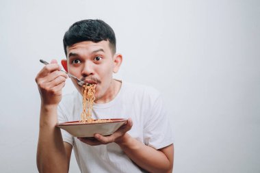 Neşeli genç bir adam minimalist bir mekanda hazır eriştenin tadını çıkarıyor..