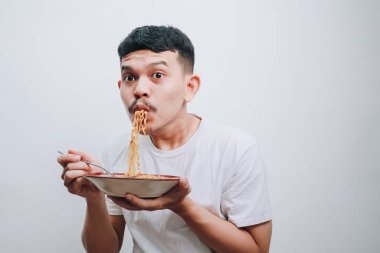 Genç bir adam bir tabak lezzetli erişteden zevk alıyor..