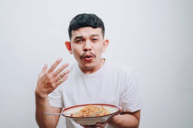 Bir adam şehriye kasesinin tadını çıkarırken yüzünde neşe ifadesi sergiliyor..