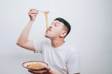 Genç bir adam hevesle hazır erişteden zevk alıyor..