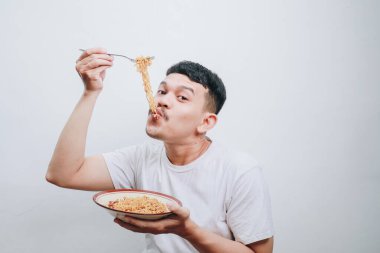 Neşeli bir gurme gülümseyerek lezzetli eriştelerin tadını çıkarıyor, mutluluğun özünü yakalıyor..