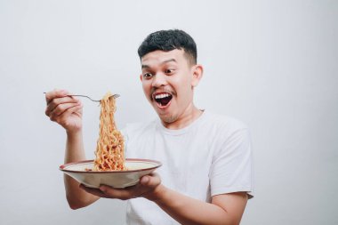 Neşeli genç bir adam erişteye olan sevgisini hoş bir ifadeyle paylaşıyor..