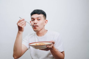 Bir adam gülümseyerek yemeğinden zevk alır, bir tatmin anını ve basitliğini yakalar..