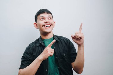 Neşeli bir adam, minimalist bir ortamda coşku ve neşe gösteriyor..