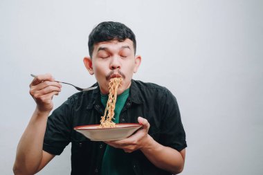 Bir insan keyifli bir ifadeyle lezzetli bir kase erişteden hoşlanır..