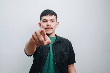 Kendinden emin genç bir adam izleyiciyi işaret eder, kararlılığı ve kendine güveni somutlaştırır..