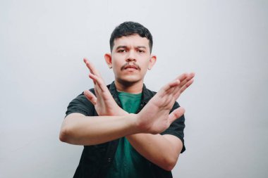 Kollarını kavuşturan bir adam meydan okuma ve kararlılık taşır..