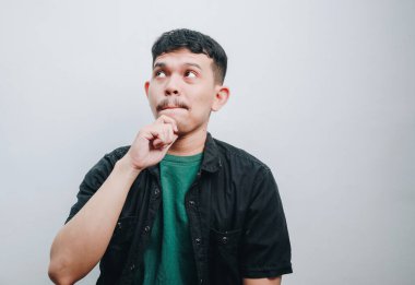 Düşüncelere dalmış, tuhaf bir ifadeyle fikirler üreten genç bir adam..