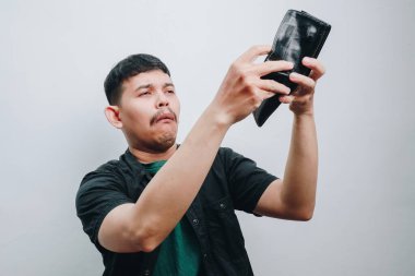 Genç bir adam siyah cüzdanıyla selfie çekerken kendini şaşırtır..