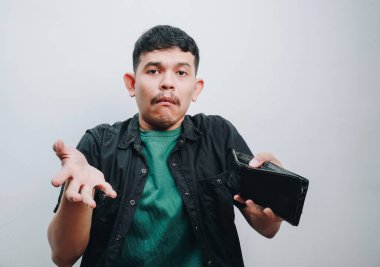 Bir cüzdan tutarken kafa karışıklığı yaşayan, belirsizlik gösteren bir adam..