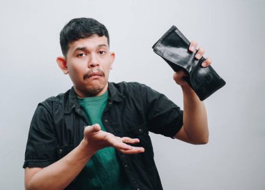 Adamın biri boş bir cüzdan gösteriyor, kafası karışmış bir şekilde, mali hayal kırıklığını ifade ediyor..