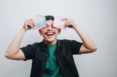 Bir adam sevinçle para gösterir, mutluluğu ve başarıyı simgeler..