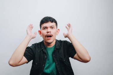 Genç bir adam şaşırmış bir yüz ifadesi sergiliyor..