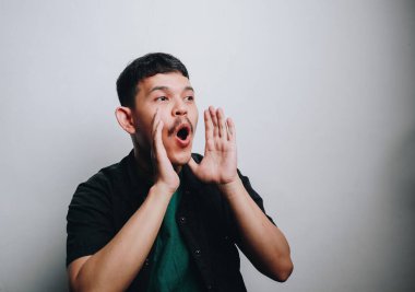 Genç bir adam sevinçle bağırıyor, basit bir çevrede heyecan ve enerjiyi somutlaştırıyor..